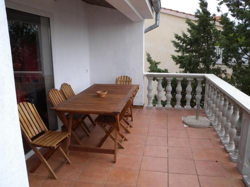 a wooden table and chairs on a balcony at Apartment in Pridraga/Zadar Riviera 7998 in Gospić