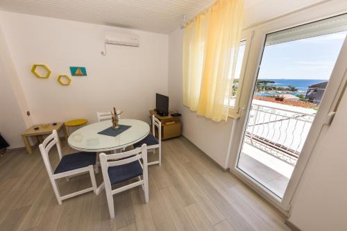 ein Zimmer mit Tisch und Stühlen und einem Balkon in der Unterkunft Apartments Sunset Dolac in Primošten