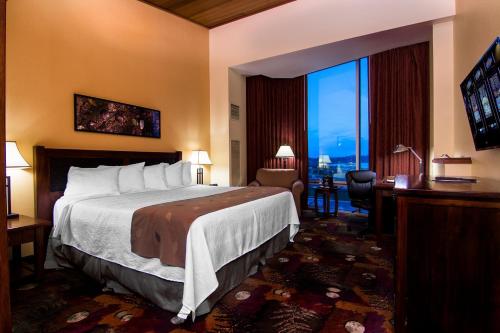 a hotel room with a bed and a large window at The Mill Casino Hotel in North Bend