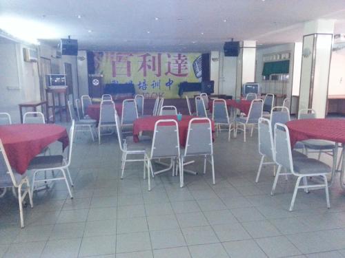 a dining room with red tables and white chairs at Pacific Orient Hotel ( 凯富大酒店 ) in Miri