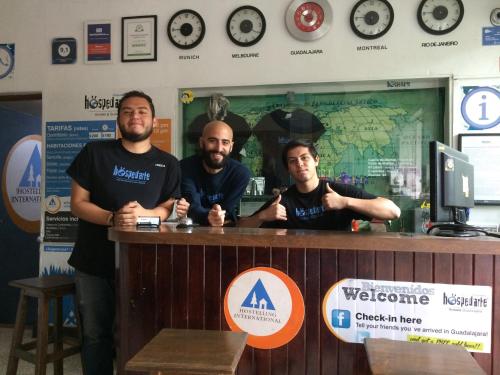 a group of three men standing at a counter at Hostel Hospedarte Chapultepec in Guadalajara