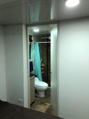 a bathroom with a toilet and a blue shower at Apt nororiente 203 in Bogotá