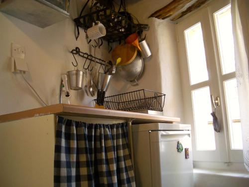 a kitchen with a refrigerator and a counter with pots and pans at Traditional Medieval Stone house in "Ano Syros" in Ano Syros