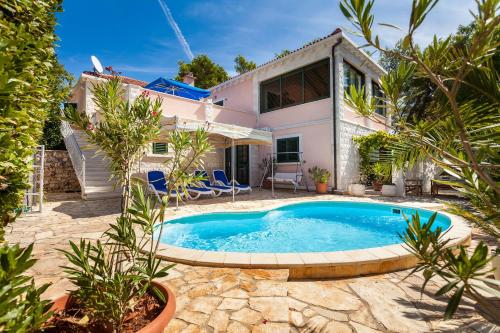 a villa with a swimming pool in front of a house at Villa Rosada in Vela Luka
