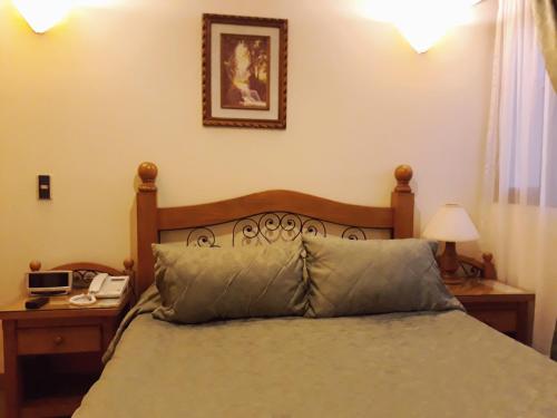 a bedroom with a bed and a phone on a table at Hotel Del Parque in La Ceja
