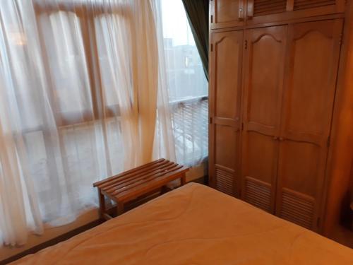 a bedroom with a bed and a dresser and a window at Hotel Del Parque in La Ceja