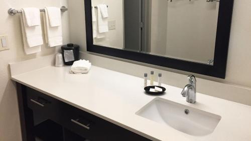 a bathroom with a sink and a mirror at Comfort Inn & Suites Tigard near Washington Square in Tigard