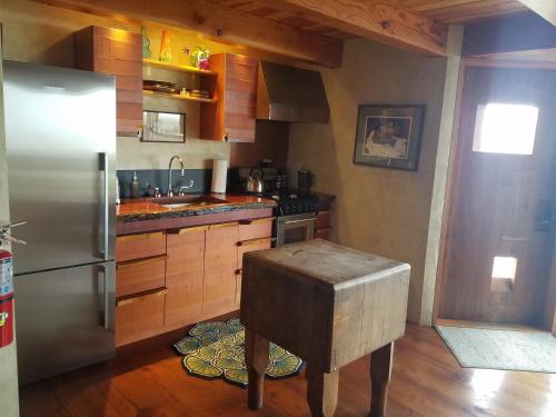 a kitchen with a stainless steel refrigerator and a wooden floor at The Inn at Newport Ranch in Fort Bragg