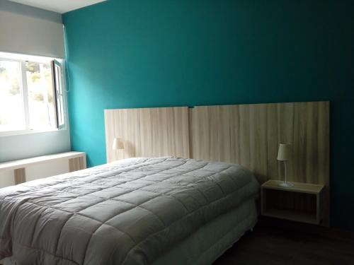 a bedroom with a bed and a blue wall at Vuela Gaviota in Mar Azul