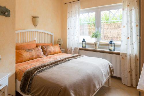 een slaapkamer met een groot bed en een raam bij Altes Strandhus Casa Stranddune in Scharbeutz