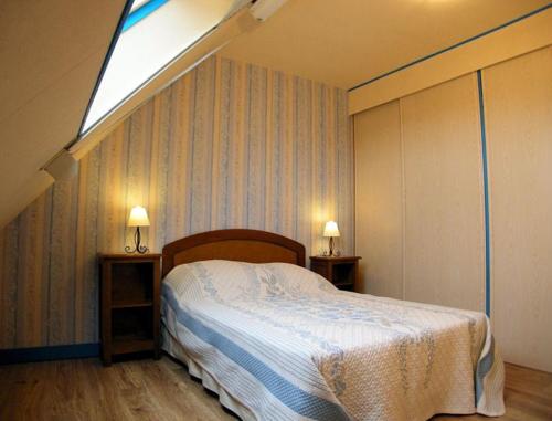 een slaapkamer met een bed en 2 tafels met lampen bij Gîte de Pont C'Hoat in Névez