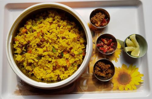 a bowl of rice on a tray with bowls of ingrediants at Bhaskar Homestay in Dibrugarh