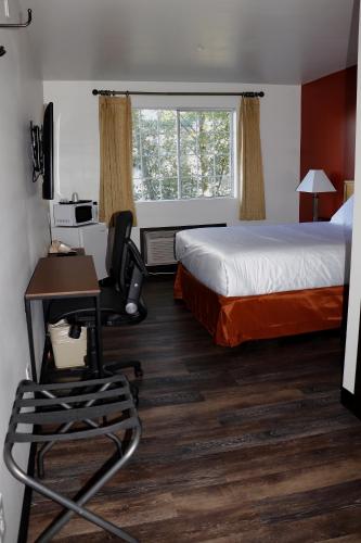 a hotel room with a bed and a desk and chair at Best Lynnwood Inn in Lynnwood