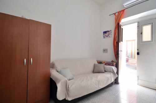 a living room with a couch and a wooden cabinet at Ai Piedi del Castello di Castelsardo in Castelsardo