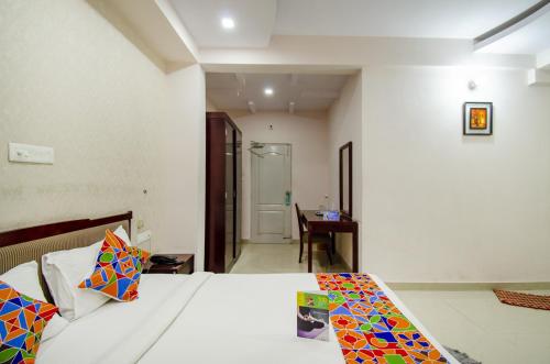 a bedroom with a bed with colorful pillows on it at FabExpress Oriental Suites III - BTM Mico Layout in Bengaluru