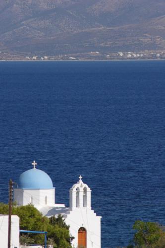 a white church in front of the ocean at Elena Studios & Apartments in Piso Livadi