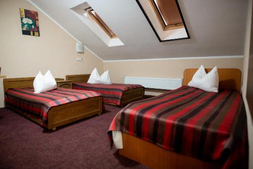 サトゥ・マーレにあるVila Tineretuluiのベッド2台と窓が備わるホテルルームです。