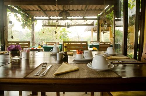 a wooden table with plates and utensils on it at Villa Khao Phaengma in Wang Nam Khieo