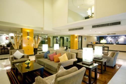 a large living room with couches and tables at Kantary House Hotel, Bangkok in Bangkok