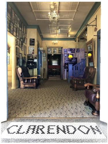 a living room with two chairs and a television at The Clarendon Motel Katoomba in Katoomba