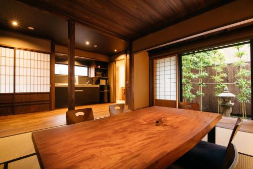 een eetkamer met een houten tafel en stoelen bij Ryu TABI-NE in Kanazawa