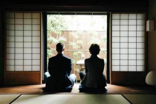 mężczyzna i kobieta siedzący przed oknem w obiekcie Ryu TABI-NE w mieście Kanazawa