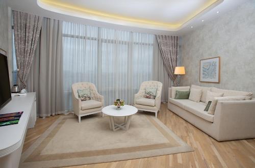 a living room with a couch and chairs and a table at Qafqaz Sahil Hotel Baku in Baku
