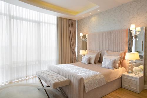 a bedroom with a large bed and a large window at Qafqaz Sahil Hotel Baku in Baku
