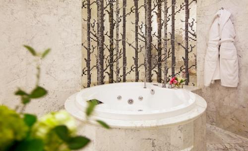 a bathroom with a tub with a black and white wall at Qafqaz Sahil Hotel Baku in Baku