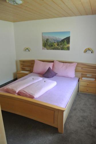 カウナータールにあるApart Dorfblickのベッドルーム1室(ピンクの枕が付いた大型ベッド1台付)