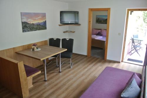 カウナータールにあるApart Dorfblickのテーブルと椅子、テレビが備わる客室です。