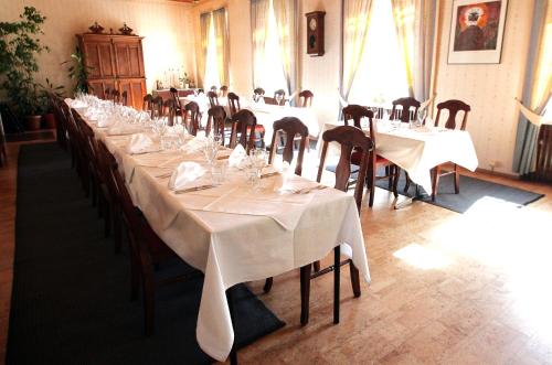 a long dining room with white tables and chairs at Hotel Merihovi in Kemi