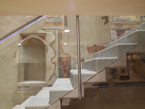 a staircase in a building with paintings on the walls at Palazzo Ai Capitani in Peschiera del Garda