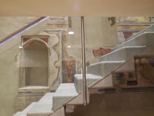 eine Treppe in einem Gebäude mit Gemälden an den Wänden in der Unterkunft Palazzo Ai Capitani in Peschiera del Garda