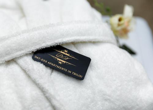 トビリシにあるDat Exx Apartmentsの白い毛布の上に座る黒札