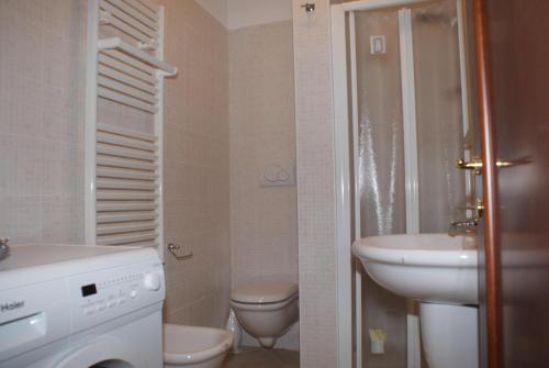 a bathroom with a toilet and a sink and a washing machine at Giacomo Home in Marina di Cecina