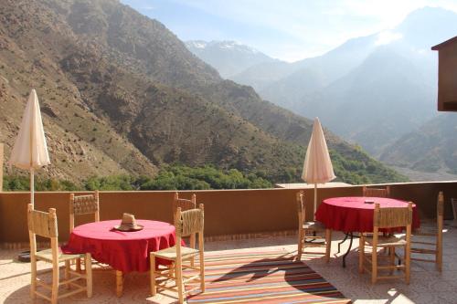 two tables and chairs with a view of a mountain at Dar Imperial in Imlil