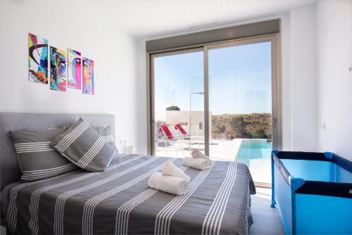a bedroom with a bed with towels on it at Stunning Villa Mistral Private pool in Busot