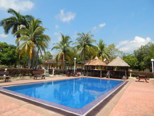 a swimming pool in a resort with palm trees at Rumbia Resort Villa Paka in Paka