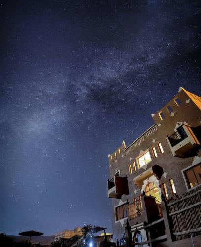 a starry night with the milky way above a building at Riad Dar Bab Todra in Tinerhir