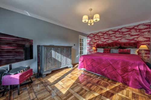 1 dormitorio con 1 cama rosa y TV en Le Park, en Bucarest
