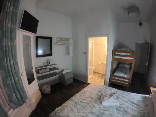 a bedroom with a bed and a mirror and a bathroom at The Danescourt in Blackpool