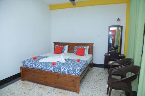 a bedroom with a bed with red and white pillows at Villa Sidu in Induruwa