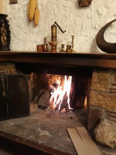 a brick fireplace with a fire in it at Apartment Suzana in Mavrovo