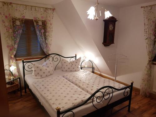 1 dormitorio con 1 cama con reloj en la pared en Ferienwohnung Müller, en Steinach