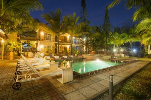 a pool in front of a house with palm trees at Talamba Blue in Blue Bay
