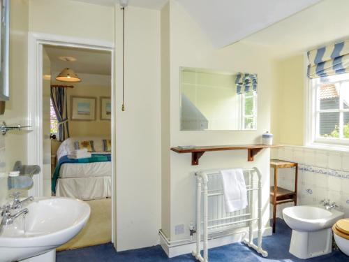 een badkamer met een wastafel en een spiegel bij 8 The Whinlands in Thorpeness