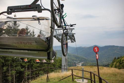 a person riding a ski lift with a bike on it at SALAMANDRA Hotel in Banská Štiavnica