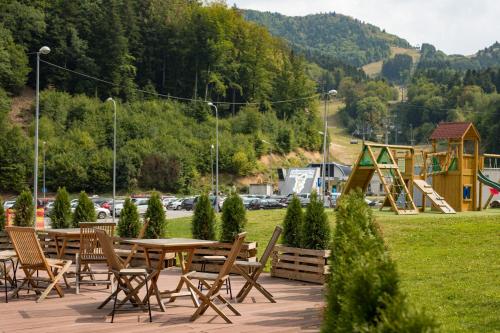 a picnic table and chairs in a park with a playground at SALAMANDRA Hotel in Banská Štiavnica