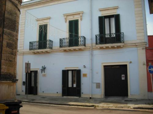 un edificio blanco con puertas y ventanas negras en Donn'Anna B&B, en Squinzano
